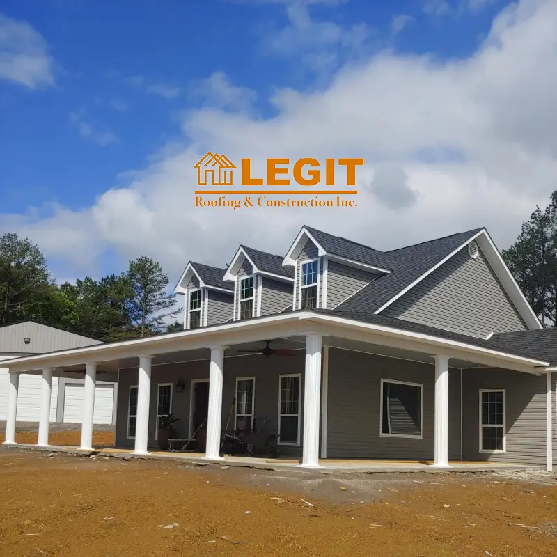 A banner for Legit Roofing & Construction Inc. with a grey house and a cloudy sky as the backdrop