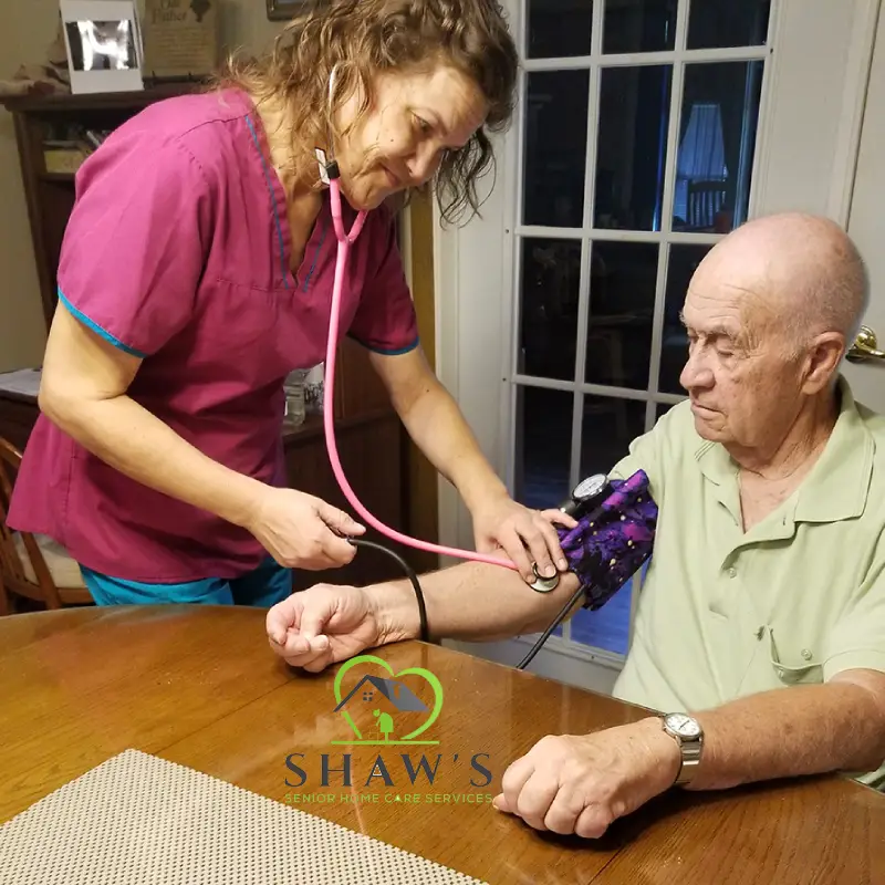 A nurse checking the blood pressure of an elderly person