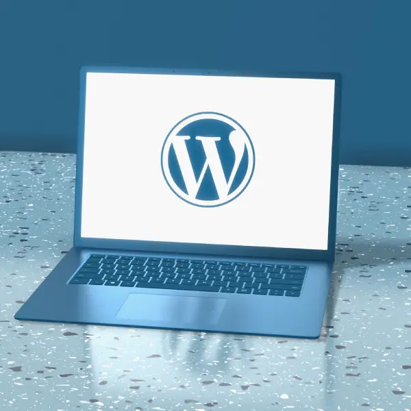 The WordPress logo "W" symbol being displayed on a laptop screen