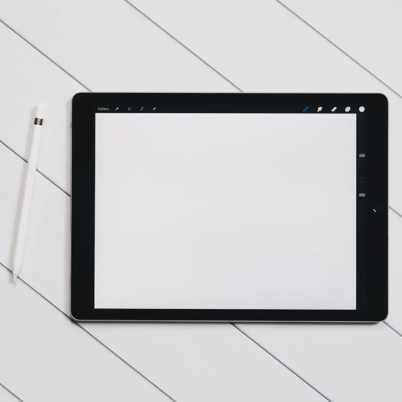 An image of an iPad with a white screen and an Apple pen beside it.